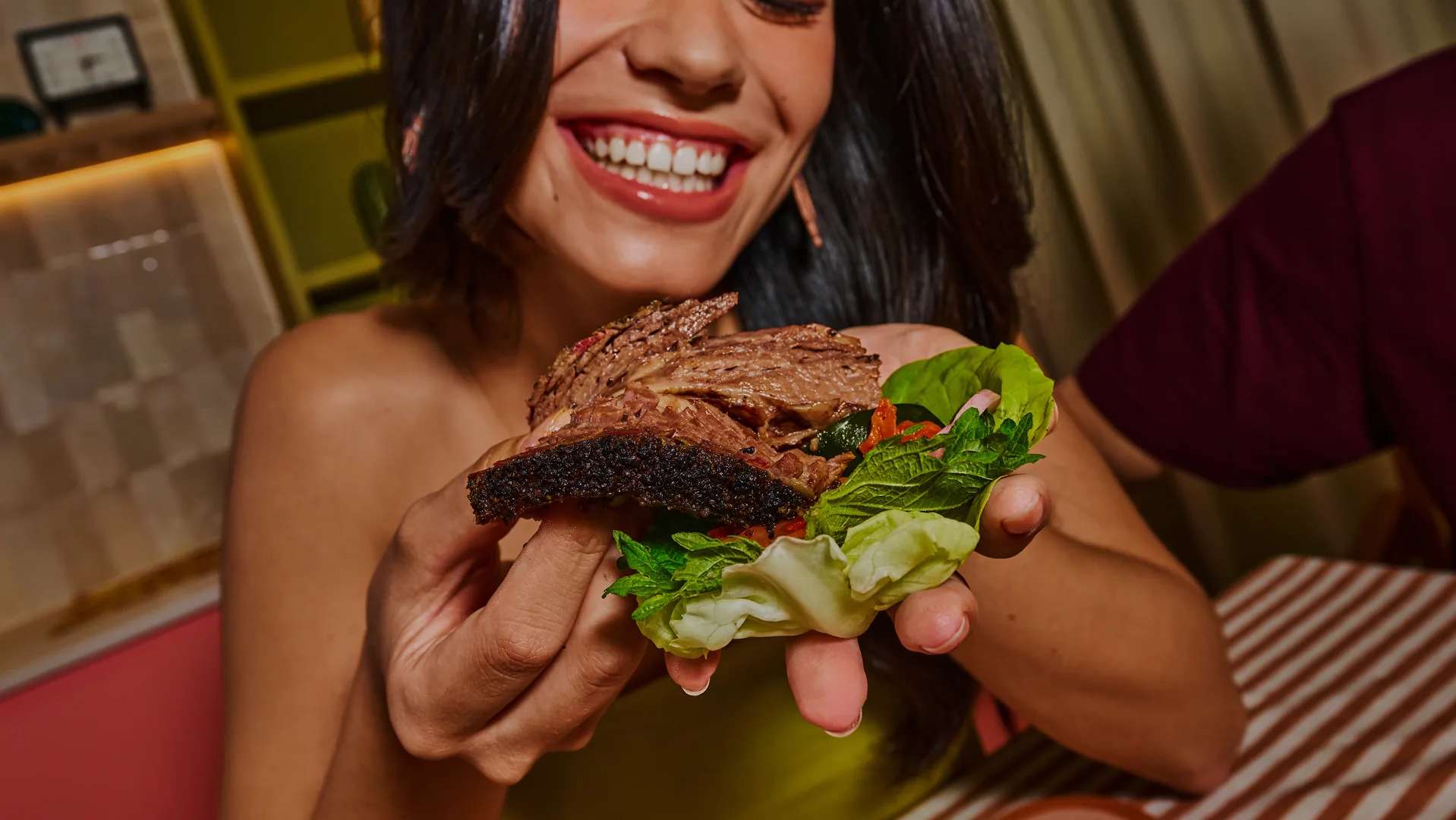 Someone biting into a smoked-meat wrap