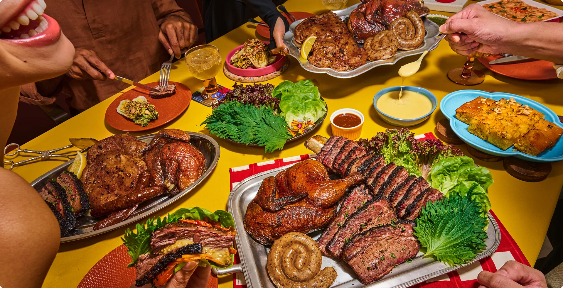 A table piled with smoked-meat platters and sides
