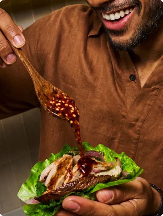 Spooning Asian sauce onto a wrap
